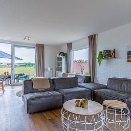Gezellige woonkamer van Huisje in De Koog, Texel, met uitzicht op het landschap van de Waddeneilanden.