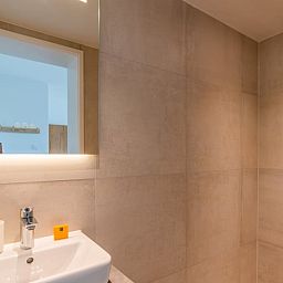 Stijlvolle badkamer in Huisje in De Koog, Texel, met moderne douche en wastafel.