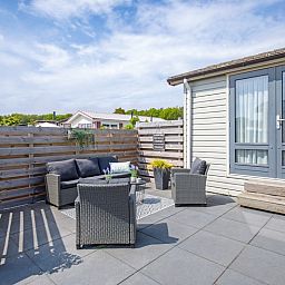 Zonnig terras met comfortabele zitplaatsen bij Chalet Bregkoog 88 in De Koog, Texel, gelegen op Chaletpark Bregkoog.