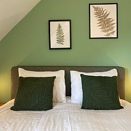 Detail des Doppelbetts mit gruenen Kissen in De Boomleeuwerik, Texel.