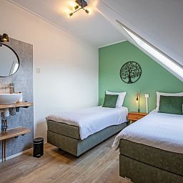 Geraeumiges Schlafzimmer mit zwei Einzelbetten in De Boomleeuwerik, Texel.