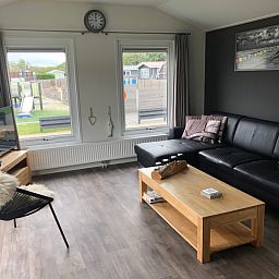 Geraeumiges Wohnzimmer mit bequemem Sofa im Chalet Bregkoog 226, De Koog, Texel.