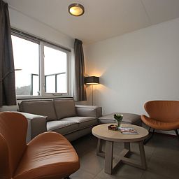 Gezellige woonkamer in Vakantiehuis, De Koog, Texel met comfortabele zithoek en moderne inrichting voor een ontspannen verblijf.