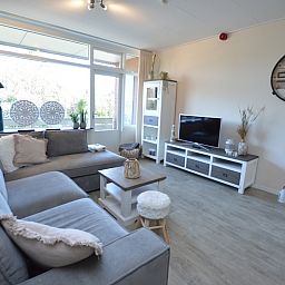 Heller Wohnraum im Apartment Kerckeland 78, Ferienhaus in De Koog, Texel, mit grossen Fenstern und stilvollen Moebeln.