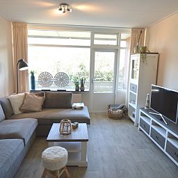 Stilvolles Wohnzimmer des Appartements Kerckeland 78, De Koog, Texel, mit Blick auf die natuerliche Umgebung.