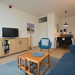Modernes Wohnzimmer mit TV und Buecherregal im Apartment Kerckeland 126, Texel.