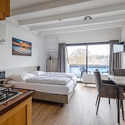 Gezellige binnenruimte van Twee persoons studio Texel met eethoek en grote ramen.