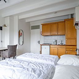 Praktische keuken in Twee persoons studio Texel met houten kasten en compacte eethoek.