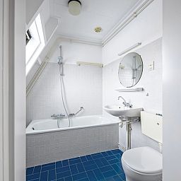 Moderne badkamer in Twee persoons studio tweede etage op Texel met ligbad en frisse uitstraling.