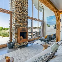 Gezellige woonkamer in Vakantiehuisje in De Koog met open haard en uitzicht op Texelse natuur.