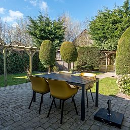 Gezellig terras bij vakantiehuisje in De Koog, Texel, omgeven door natuur.