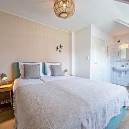 Gezellige slaapkamer in Vogelweelde, De Koog, Texel met tweepersoonsbed en zachte verlichting.