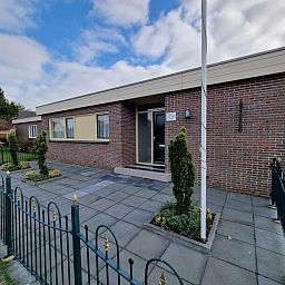 Vorderansicht des Bungalows Epelaan 13, De Koog, Texel. Ferienhaus mit moderner Backsteinfassade und geschlossenem Garten.