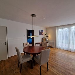 Essecke im Bungalow Epelaan 13, De Koog, Texel. Ferienhaus mit elegantem Tisch und bequemen Stuehlen fuer gemuetliche Mahlzeiten.