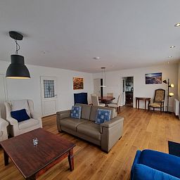 Offener Wohnbereich im Bungalow Epelaan 13, De Koog, Texel. Modern eingerichtetes Ferienhaus mit Holzboeden.