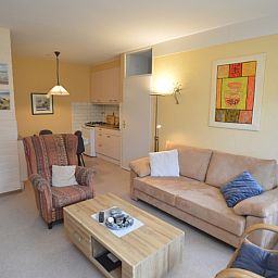 Offener Wohnbereich des Appartements Kerckeland 68 in De Koog, Texel, mit gemuetlicher Sitzecke und Kueche.