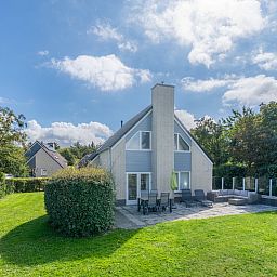 Sonnige Terrasse am Ferienhaus Honeysuckle 59 in De Koog, Texel mit bequemen Sitzgelegenheiten im Freien.