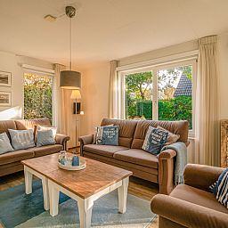 Gezellige woonkamer van Vakantiehuis Kamperfoelie 65, De Koog, Texel met comfortabele banken en veel lichtinval.