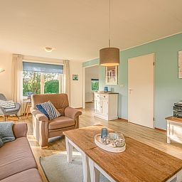 Ruime woonkamer in Vakantiehuis Kamperfoelie 65, De Koog, Texel met houten vloer en stijlvolle decoratie.