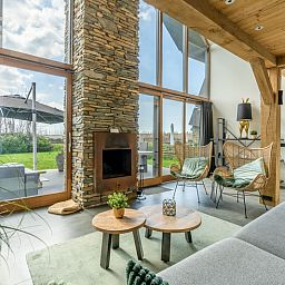 Gemuetliches Wohnzimmer der Villa 183 mit Whirlpool in De Koog Texel, mit grossen Fenstern und Kamin.