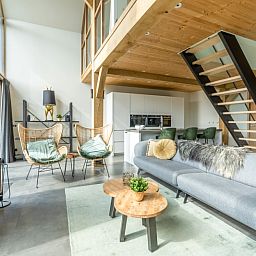 Stilvolle Inneneinrichtung der Villa 183 mit Whirlpool in De Koog Texel, mit offener Kueche und gemuetlicher Sitzecke.