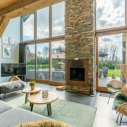 Heller und geraeumiger Wohnbereich der Villa 183 mit Whirlpool in De Koog Texel, mit Blick auf den Garten.