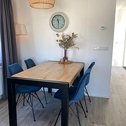 Gemuetliches Wohnzimmer im Chalet Bregkoog 94, De Koog, Texel. Bequemes Sofa und stilvolle Einrichtung fuer einen entspannten Aufenthalt.