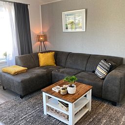 Essecke im Chalet Bregkoog 94, De Koog. Moderner Holztisch mit blauen Stuehlen, ideal fuer gemuetliche Mahlzeiten auf Texel.