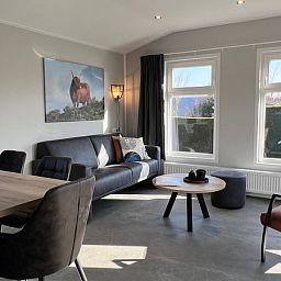 Gezellige woonkamer van Chalet Type 1 in De Koog, Texel met comfortabele zitruimte en veel natuurlijk licht.
