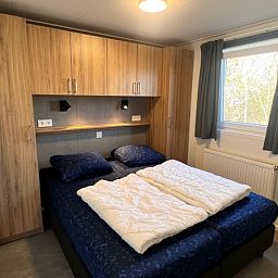 Slaapkamer met tweepersoonsbed in Chalet Type 1, De Koog, Texel voor een comfortabele nachtrust op de Waddeneilanden.