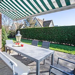 Gezellig terras met schaduw bij De Schutstal vakantiehuis in De Koog, Texel