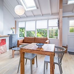 Lichte zithoek in vakantiehuis Pippa, De Koog, Texel met comfortabele bank en eettafel.