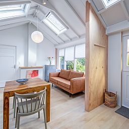 Stijlvolle binnenruimte van vakantiehuis Pippa, Texel met houten accenten en grote ramen.