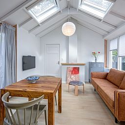 Ruime woonkamer in vakantiehuis Pippa, De Koog, Texel met uitzicht op de tuin.