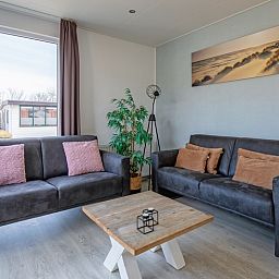 Comfortabele zithoek in Chalet Bregkoog 261, Chaletpark Bregkoog, De Koog, Texel, met uitzicht op de tuin.