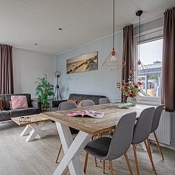 Eetruimte in Chalet Bregkoog 261, Chaletpark Bregkoog, De Koog, Texel, met een stijlvolle houten tafel en moderne stoelen.