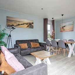Ruime woonkamer in Chalet Bregkoog 261, Chaletpark Bregkoog, De Koog, Texel, met comfortabele banken en decoratieve elementen.