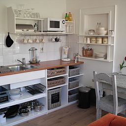 Gezellige keuken in vakantiehuis Plevierstraat 21, De Koog, Texel, met moderne voorzieningen en eetruimte op de Waddeneilanden.