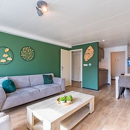 Gezellige zithoek in Appartement Anna 218, De Koog, Texel, met groene accenten en eetgedeelte.