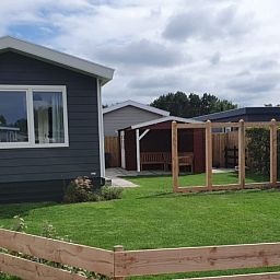 Ruime buitenkant van Chalet Bregkoog 154 in De Koog, Texel met verzorgde tuin.