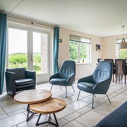Ruime woonkamer in Villa 6 personen, De Koog Texel, met comfortabele zitplaatsen en uitzicht op de tuin.