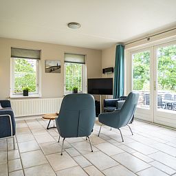 Gezellige zithoek in Villa 6 personen, De Koog Texel, met lichtinval en toegang tot het terras.