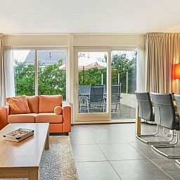 Ruim terras met parasol bij Beach Park Texel 6-persoons villa, De Koog, ideaal voor buiten dineren.