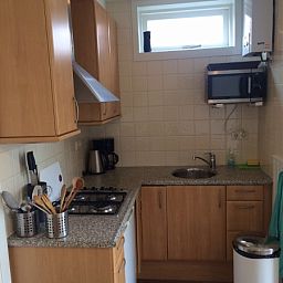 Moderne keuken in Zomerhuisje Plevierstraat 12, De Koog, Texel. Vakantiehuis met compacte keuken voorzien van alle gemakken op de Waddeneilanden.