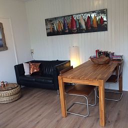 Gezellige woonkamer van Zomerhuisje Plevierstraat 12 in De Koog, Texel, met comfortabele zithoek en eettafel voor een ontspannen verblijf.