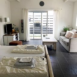 Lichte binnenruimte van Zomerhuisje Schoo in De Koog, Texel, met comfortabele zithoek.