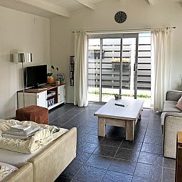 Gezellige woonkamer van Zomerhuisje Schoo in De Koog, Texel, met uitzicht op de tuin.