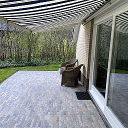 Geraeumige Terrasse mit Markise im Ferienhaus Hoog Koog 18 in De Koog, Texel, fuer ein komfortables Outdoor-Erlebnis im Bungalowpark Hoog Koog.