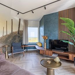 Spacious living room of Apartment Juliana 120 Eilandzicht, De Koog, Texel with beach decorations and comfortable chairs.