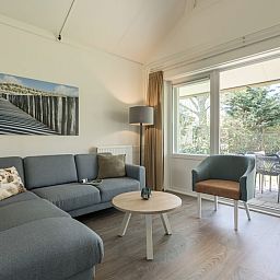 Gemuetliches Wohnzimmer im Bungalow T4 Comfort, De Koog, Texel mit Blick auf den Garten.